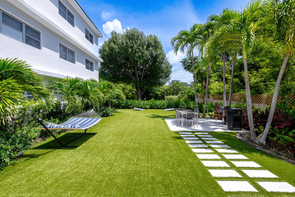 A white building with a green lawn in front of it.