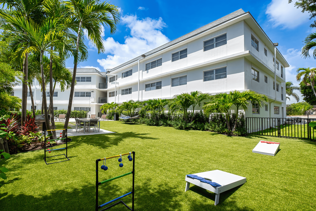 A white building with a green lawn in front.
