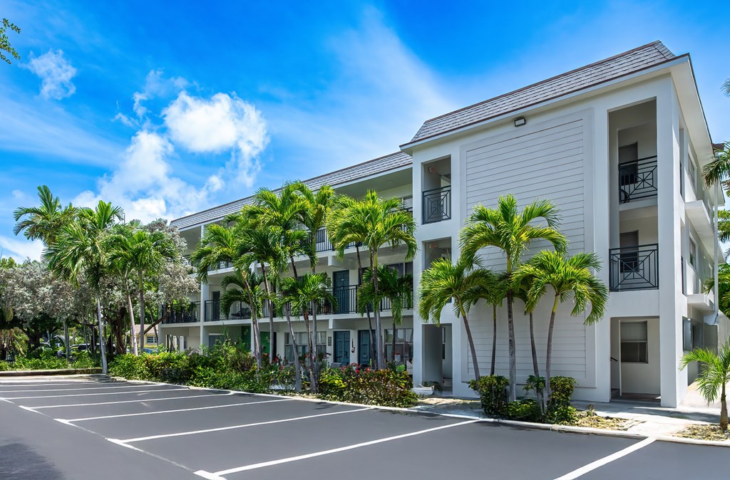 A white building with a parking lot in front of it.