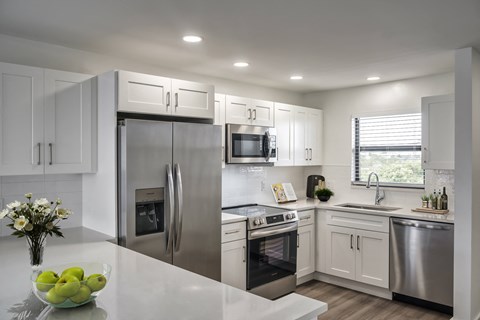a kitchen with stainless steel appliances and white cabinets