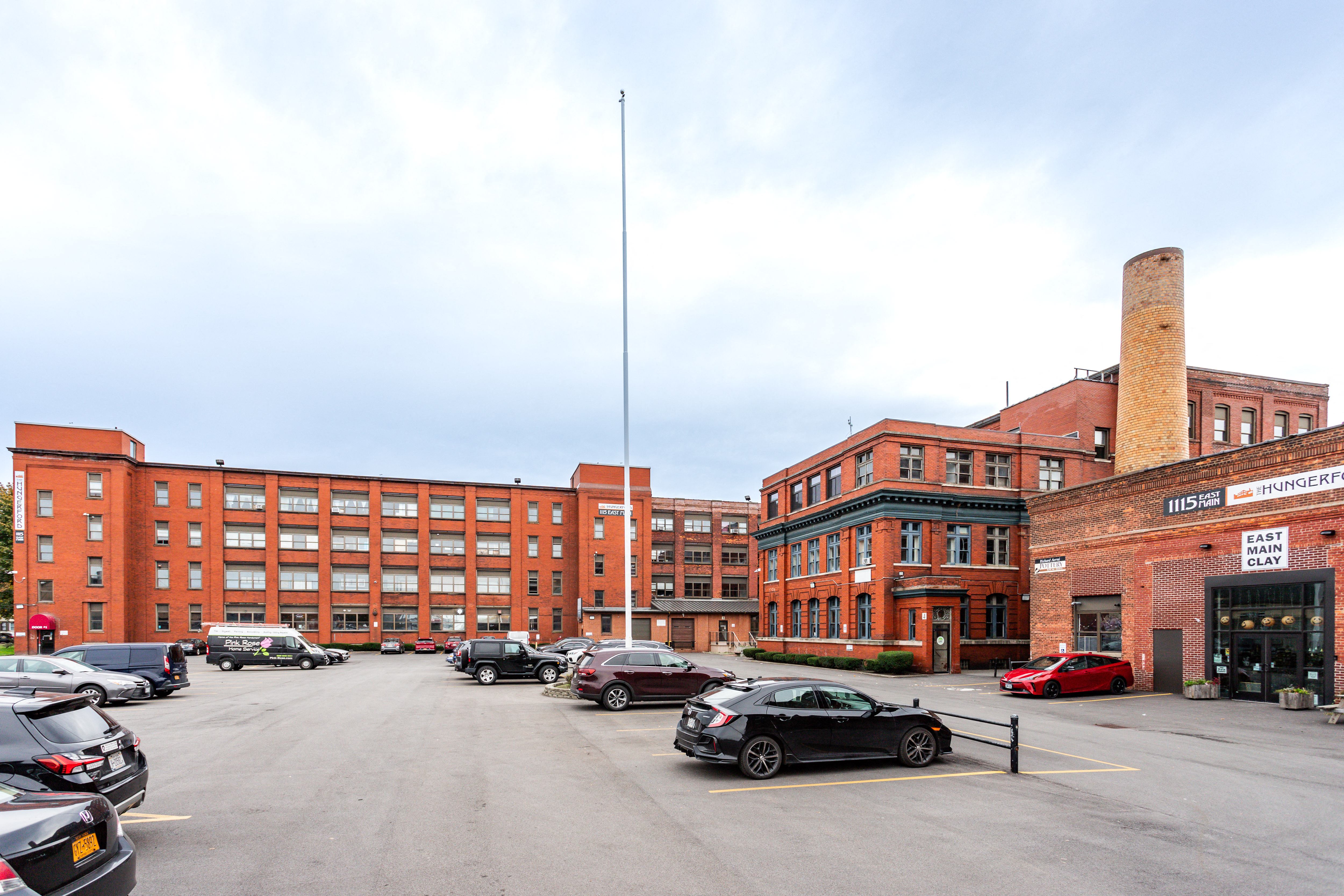a parking lot in front of a large brick building with cars parked