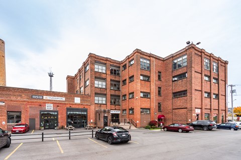 A parking lot with cars and a red brick building.