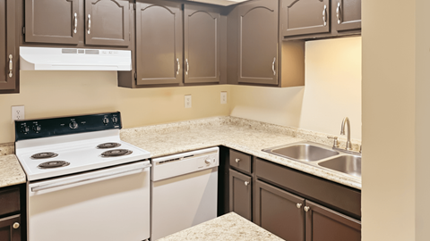 A kitchen with brown cabinets and a white oven.