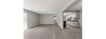 A room with light wood flooring and white walls.