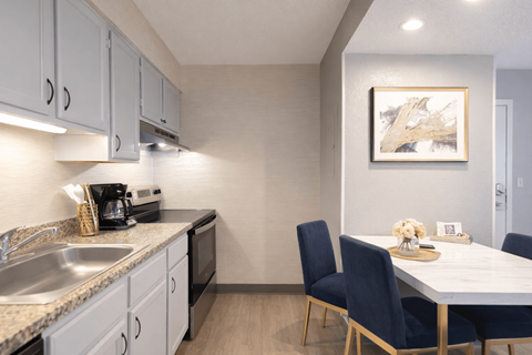 A kitchen with a table and chairs.