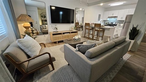A living room with a grey couch and a wooden chair.