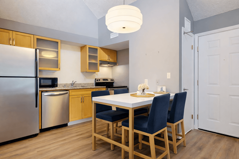 A kitchen with a table and chairs.