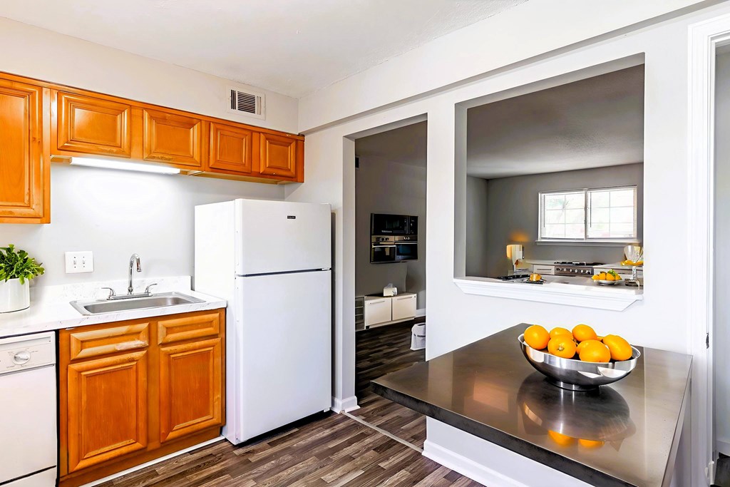 A kitchen with a white refrigerator and wooden cabinets.