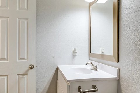 A white bathroom sink with a mirror above it.