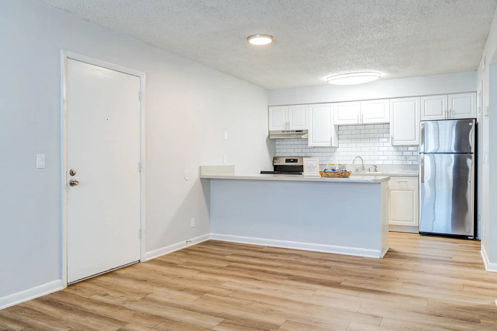 A kitchen with a white door and a white fridge.