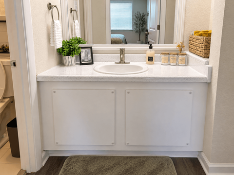 A bathroom with a white sink and a mirror above it.
