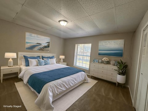 A bedroom with a large bed and a painting on the wall.