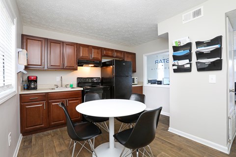 A kitchen with a table and chairs.