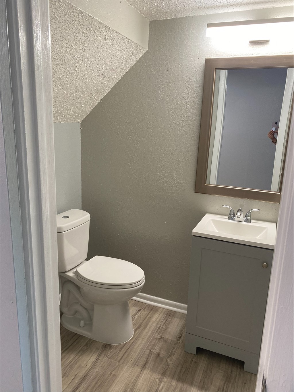 a small bathroom with a toilet sink and mirror