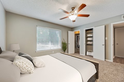 a bedroom with a large bed and a ceiling fan