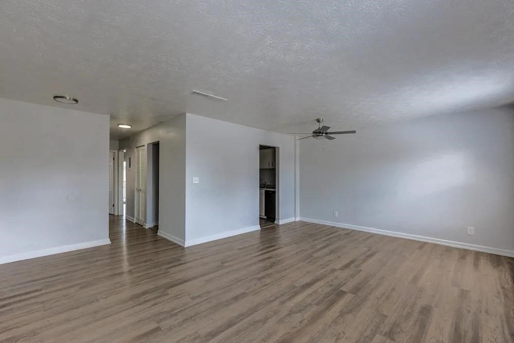 A room with wooden flooring and a ceiling fan.