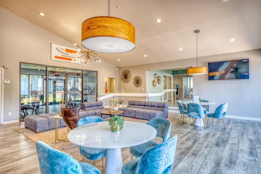 A modern dining room with a glass table and blue chairs.