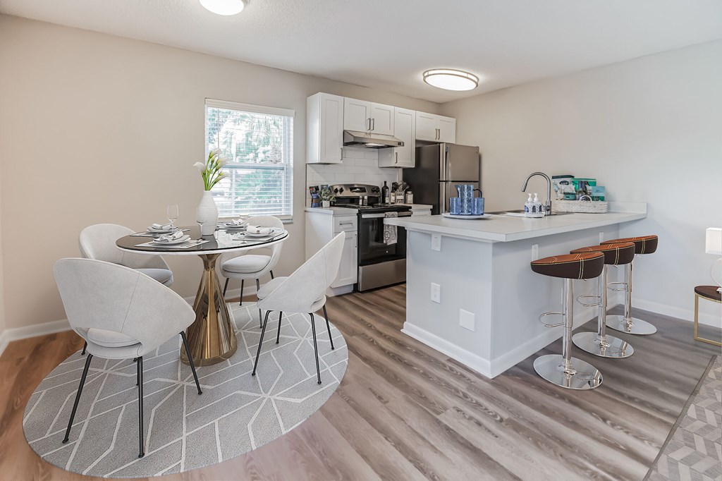 A kitchen with a table and chairs in the middle of the room.