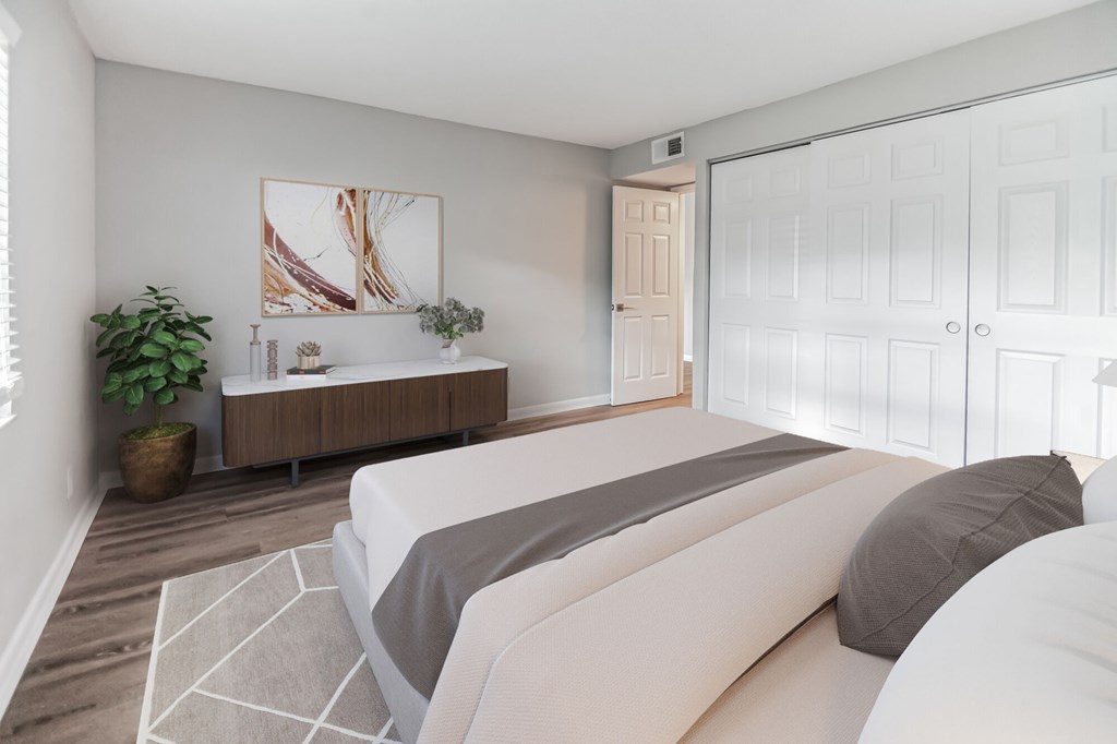 A bedroom with a large bed and a wooden cabinet.