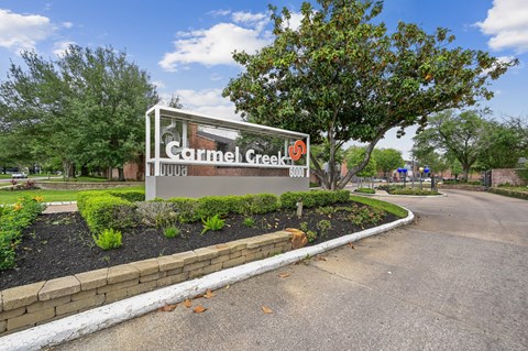 A sign for Cormel Creek is displayed in front of a landscaped area.