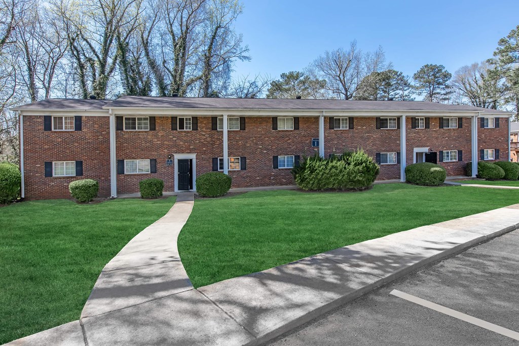 A brick building with a green lawn in front.