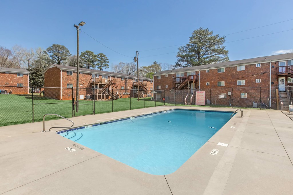 A swimming pool in front of a brick building.
