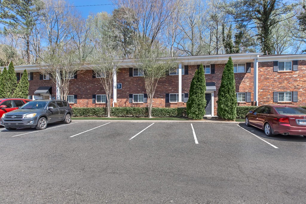 A parking lot with cars and a building in the background.