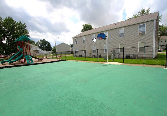 a large fenced in yard with a playground and a house