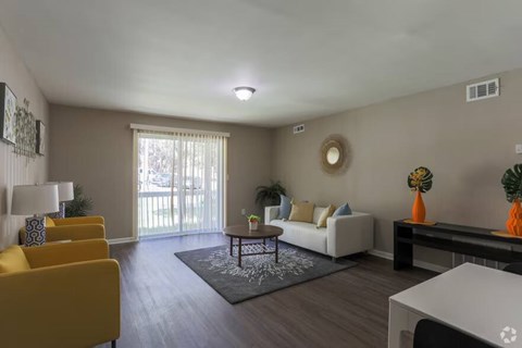A living room with a white couch, yellow chairs, and a coffee table.