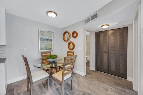 A dining room with a glass table and chairs.