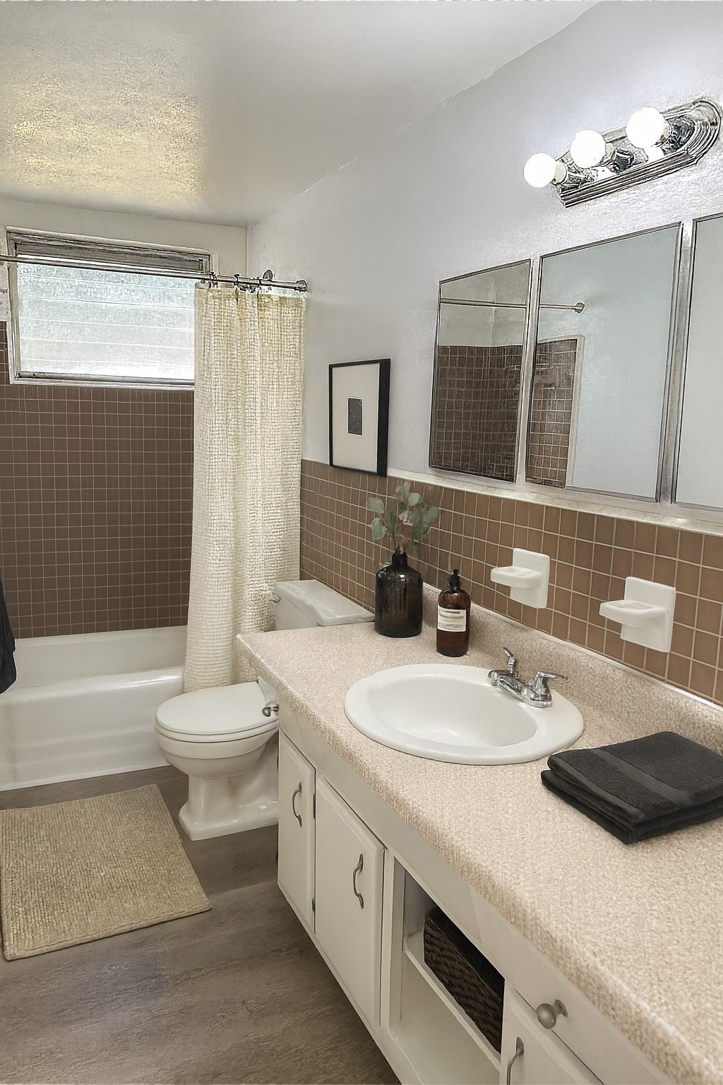 A bathroom with brown tiles and a white toilet.