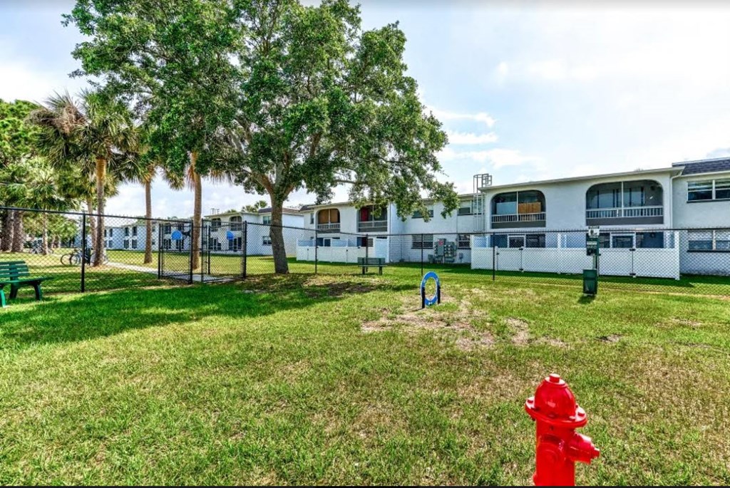 a red fire hydrant in the grass outside of a building