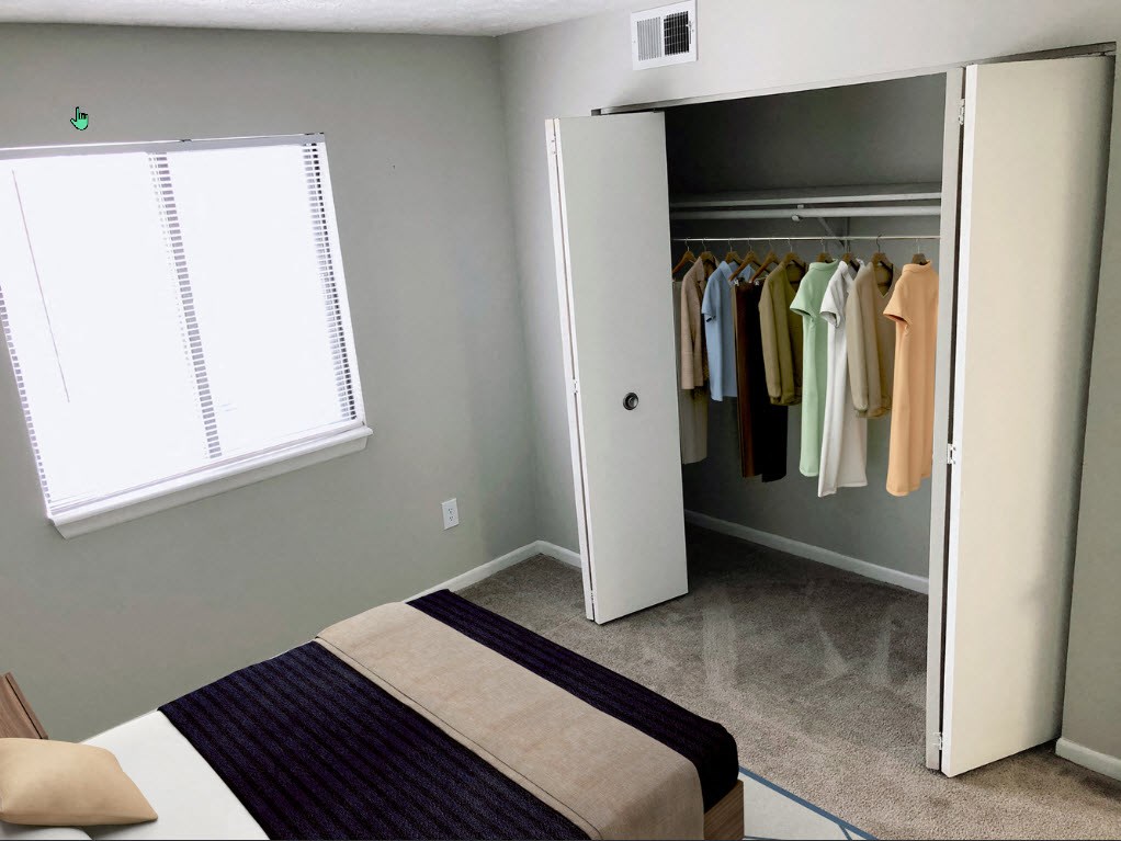 A bedroom with a bed, a window, and a closet with clothes.