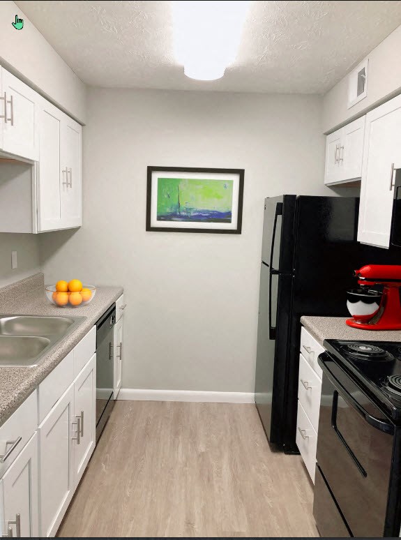 A kitchen with black appliances and white cabinets.