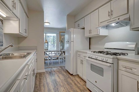 A kitchen with white appliances and cabinets.