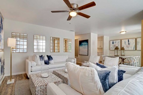 A living room with a white couch and a ceiling fan.