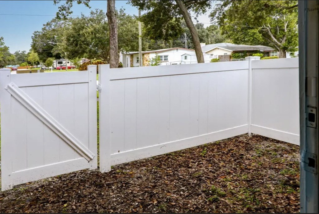 a white vinyl fence with a gate in a yard