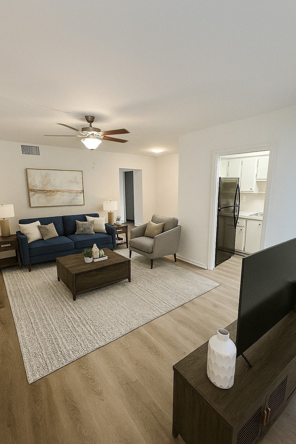 A living room with a blue couch, a coffee table, and a television.
