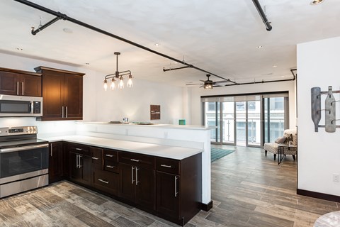 A modern kitchen with dark wood cabinets and stainless steel appliances.