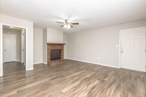 A room with a fireplace and wood flooring.