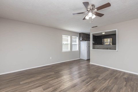 A room with a ceiling fan and a refrigerator.