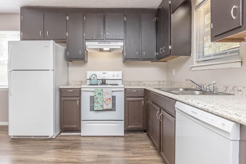 A kitchen with a white refrigerator, a white oven, and a white dishwasher.