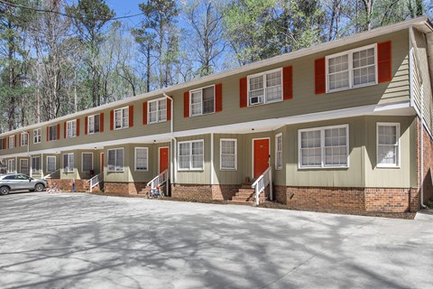 A long building with red doors and windows.