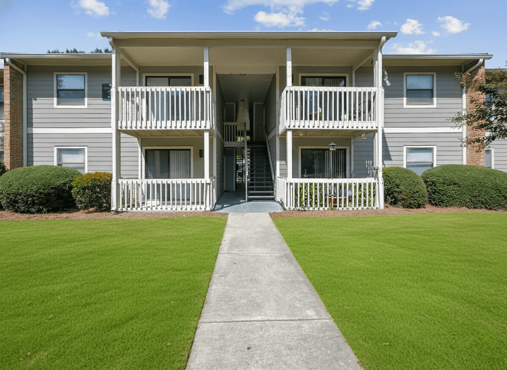 A two-story apartment building with a balcony on the second floor.