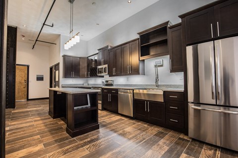 A modern kitchen with dark wood cabinets and stainless steel appliances.