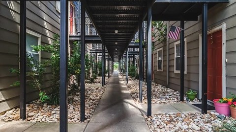 A long, narrow alleyway with a metal roof and stone ground.