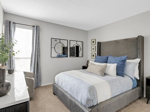 A bedroom with a large bed and a mirror on the wall.