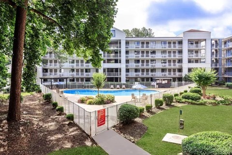 A large building with a pool in front of it.