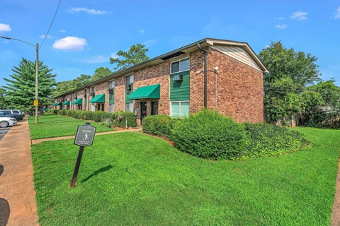 A building with a green awning and a sign in front of it.
