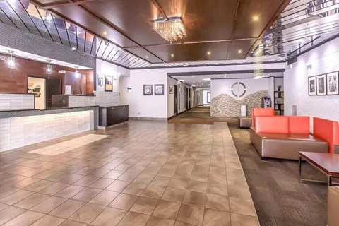 A spacious room with a long hallway and a reception desk on the left.